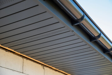 Metallic soffit and plastic gutters blend modern design
