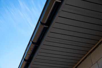 Gray perforated metal soffit on a house with gutter system