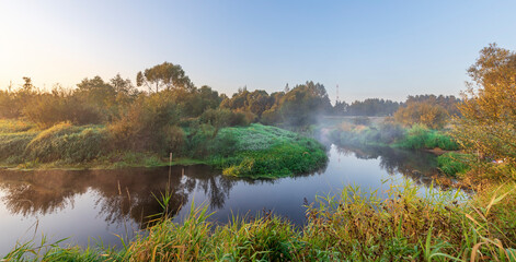 A river with a foggy mist in the background