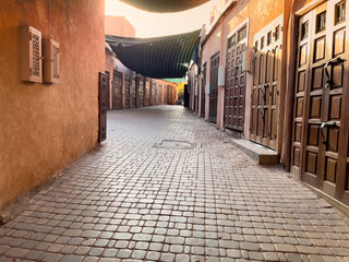 A narrow, cobblestone street lined with closed wooden doors in Morocco