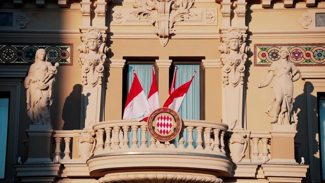 The coat of arms of Monaco and multiple flags waving on the Monte Carlo Casino