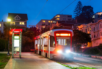 Fototapeta premium Light Rail Streetcar Stopped at Mission Dolores Park at Night in San Francisco, California, USA
