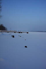 zasypany śniegiem pomost na jeziorze  © klimekm