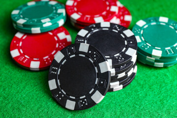 Poker game. Casino chips on green table, closeup