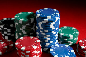 Poker game. Casino chips on red table, closeup