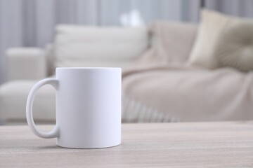 One blank ceramic mug on white wooden table. Mockup for design