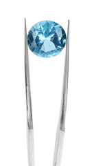 Tweezers with shiny light blue gemstone isolated on white