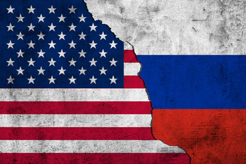 The crack between the Russian Federation and USA flags on the concrete wall. The concept of sanctions, trade war, the deterioration of diplomatic relations, confrontation and severance of agreements.