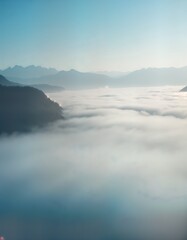 Obraz premium Mountains peak above thick fog sea. Sunrise light illuminates cloudscape. Misty morning view. Nature landscape. Calm serene scene. Perfect for travel poster brochure website banner. Ideal for