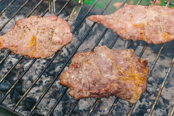 Fresh juicy pork secreto fillet and condiments roasting in a grill charcoal