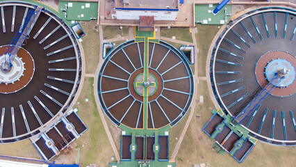 Aerial view of wastewater treatment plant with circular clarifiers, showcasing infrastructure, walkways, and operational facilities for urban water management solutions.
