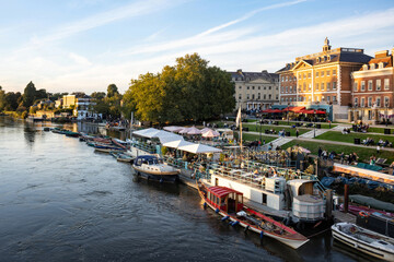 Richmond Upon Thames riverside area bustling with anonymised people in the early evening