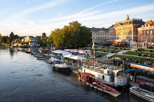 Richmond Upon Thames riverside area bustling with anonymised people in the early evening