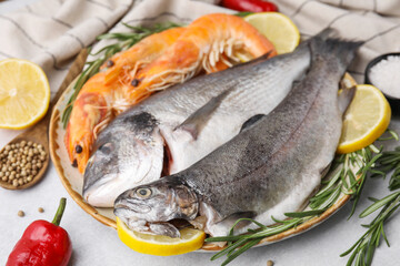 Different fresh sea food with spices on light grey table, closeup