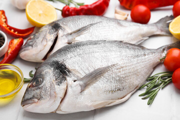 Sea food. Fresh raw fish and products on white tiled table, closeup