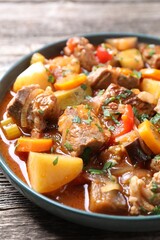 Delicious stew with vegetables on wooden table, closeup