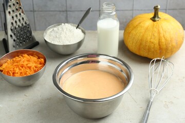 Bowl with dough and ingredients for pumpkin pancakes on light table