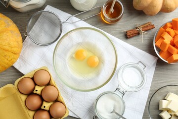 Different ingredients for pumpkin pancakes on wooden table, flat lay