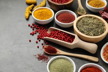 Different aromatic spices on grey table, closeup