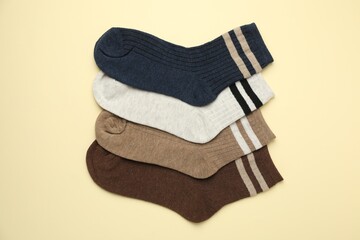 Different comfortable socks on beige background, flat lay