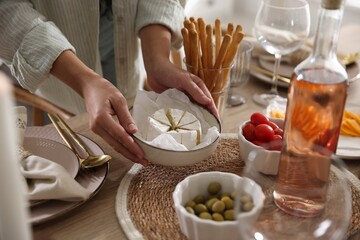 Woman setting table for dinner at home, closeup
