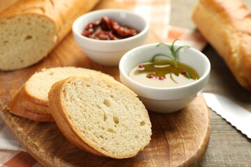 Cut fresh baguette served on wooden table, closeup