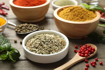 Different aromatic spices on wooden table, closeup
