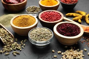 Different aromatic spices on black table, closeup