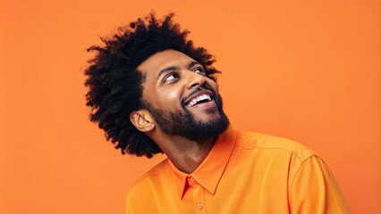 A vibrant portrait of an artist wearing a bright orange shirt with an equally vivid orange background. Their animated expression conveys creativity and enthusiasm while the