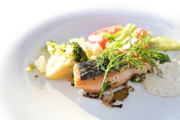 Char fillet fried on the skin with vegetables and remoulade sauce on a white plate, fish course in a menu, healthy low carb meal, copy space, selected focus,