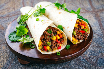 Mexican style burritos - tortilla wrap with spicy minced meat, vegetables and leek served as...