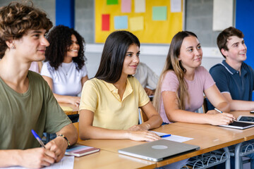 Multiracial young group of teenage Gen Z students listening to a lecturer at high school lesson. Education concept