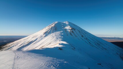 Snow-covered mountain and clear blue sky, showcasing winter serenity and rugged natural beauty.