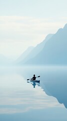 Fototapeta premium A lone kayaker paddles through serene, misty waters surrounded by majestic mountains, AI