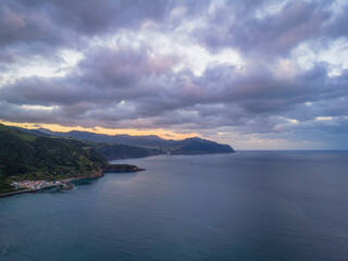 Fototapeta premium Aerial drone view of sunset over Azores islands. Ribeira Quente and Praia do Fogo. Landscape of Sao Miguel coastline with green mountains in Azores