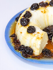 Traditional Brazilian coconut flan dessert known as manjar branco, manjar de coco and manjar dos deuses. Served with plum syrup.