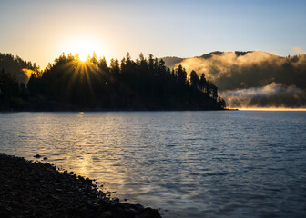 Sunstar on a forest lake. Couer d'Alene Idaho.