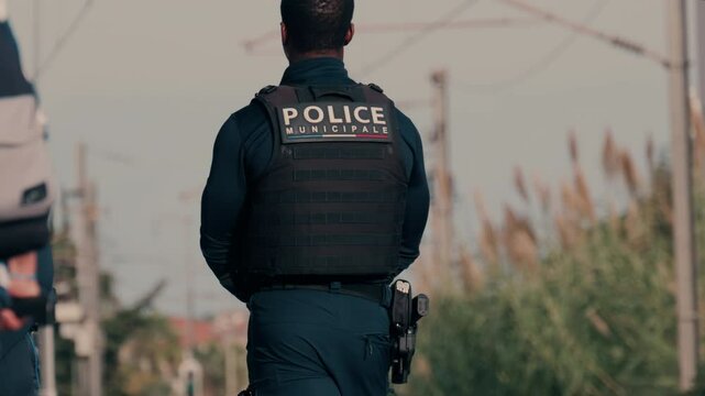 Two french police officers walking and patrolling the streets in Nice, France
