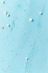 Pastel blue textured background with scattered sprinkles and delicate white flowers.