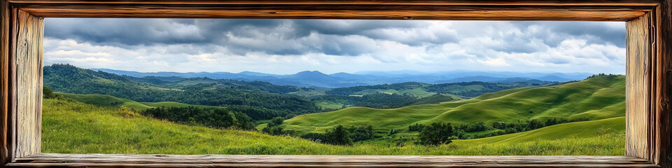Fototapeta premium A plain wooden window frame, showcasing a scenic view of rolling hills and a cloudy sky.