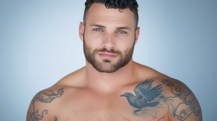 Fototapeta premium Tattooed man with intense gaze and sky blue background