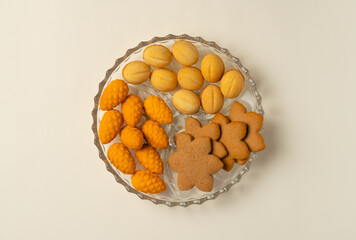 Plate with cookies on beige background. Flat lay, top view.