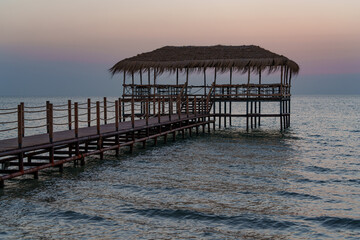 Obraz premium A beautiful view of the sunrise, sunset over the sea horizon with a pier in the foreground