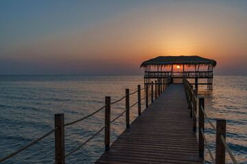 Obraz premium Piękny widok na wschód i zachód słońca nad horyzontem morskim z molo na pierwszym planie