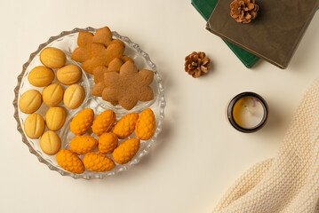 Coziness composition with cookies, books and plaid on beige background. Flat lay, top view.