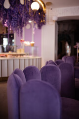 Interior of a cafe in purple colour with velvet purple furniture