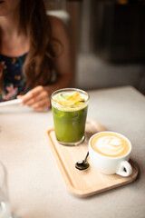 Glass of matcha green tea latte on white table at vintage cafe