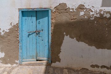 Very old and dilapidated building facade with old trees