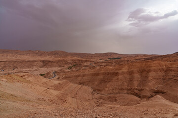 A view of the rocky and mountainous desert that is crossed by an asphalt road.