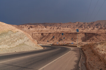 A view of the rocky and mountainous desert that is crossed by an asphalt road.